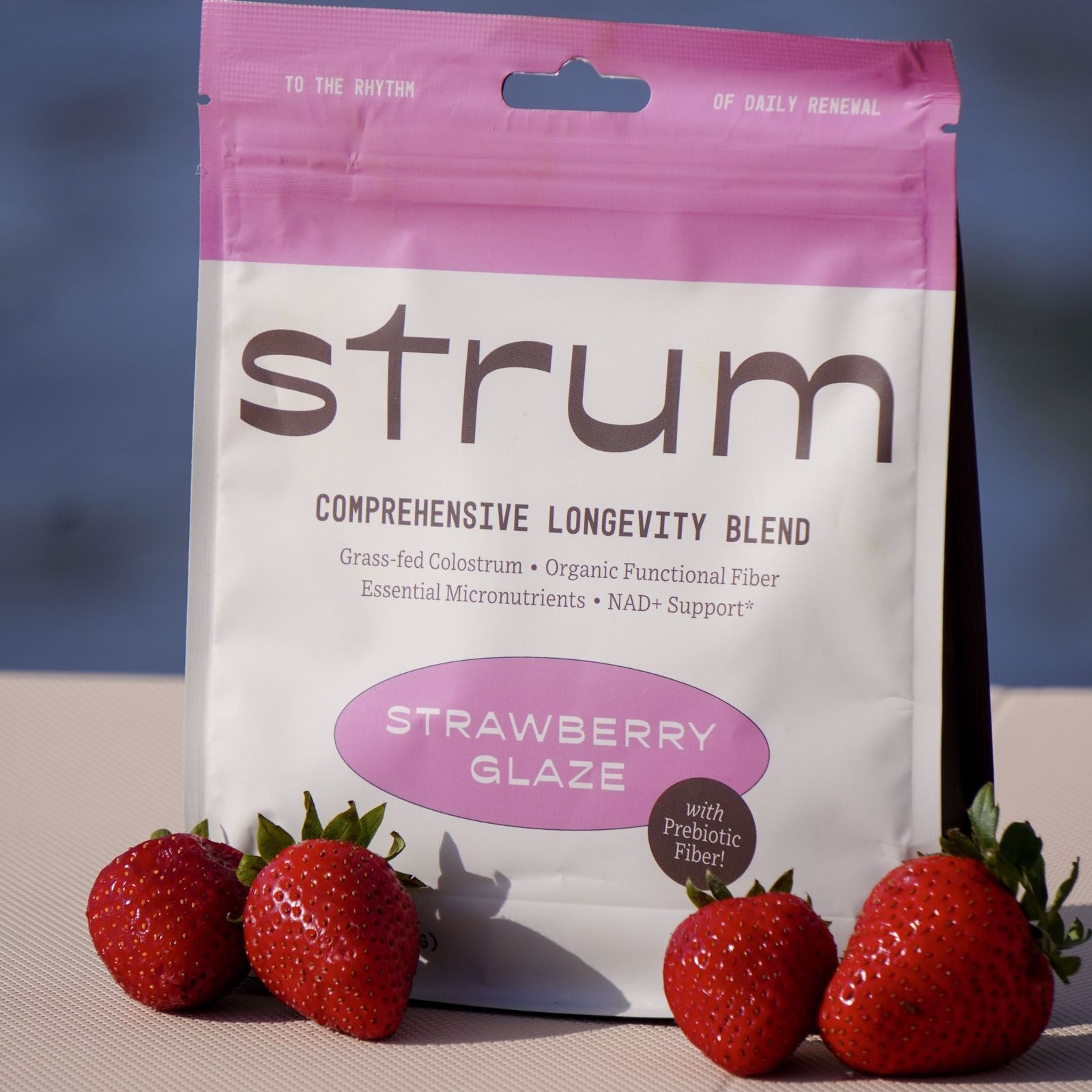 Strum Daily Longevity pouch with fresh strawberries