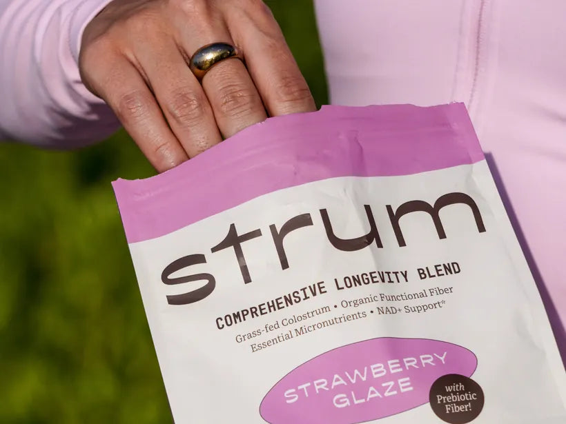 Strum Strawberry Glaze pouch held in hand